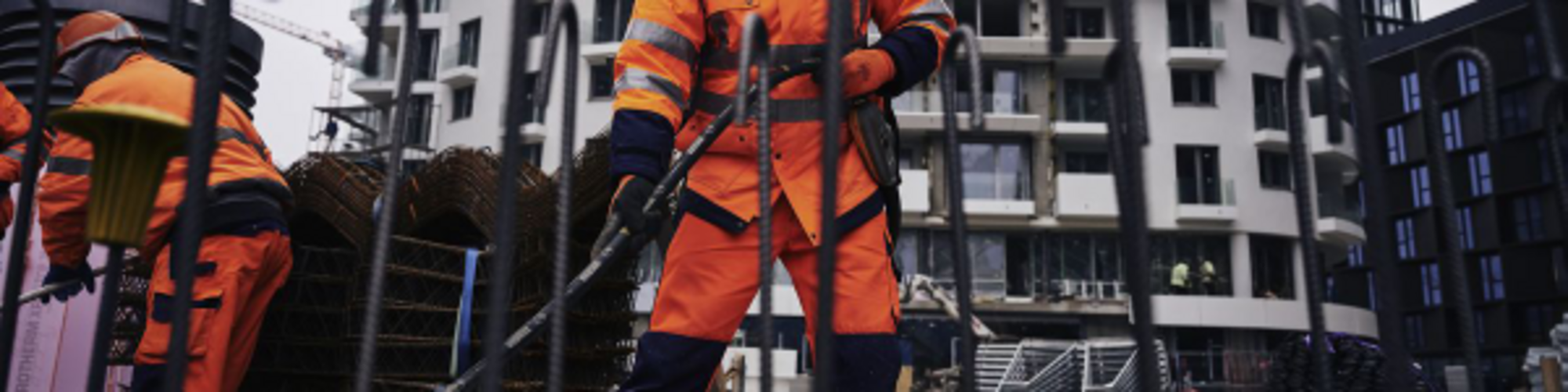 Een bouwvakker op een bouwplaats verdicht beton met een trilnaald van Wacker Neuson.