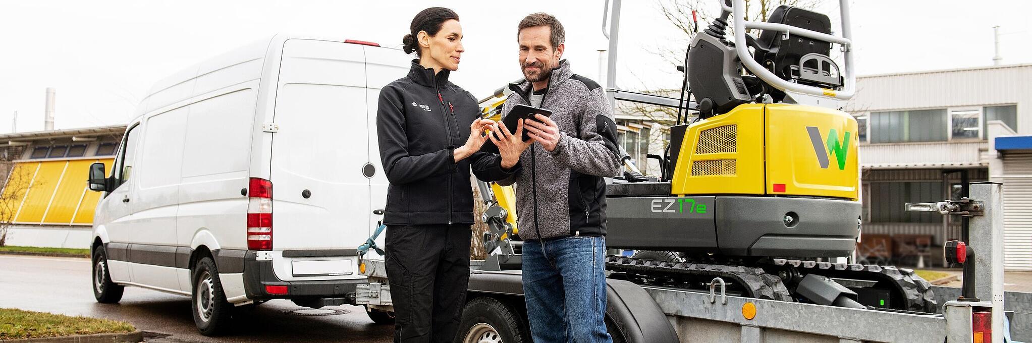 Een medewerker van Wacker Neuson en klant voor Zero Emission-rupsgraafmachine sluiten huurovereenkomst af.